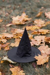 Black witch hat on a field of autumn leaves, perfect for Halloween theme.
